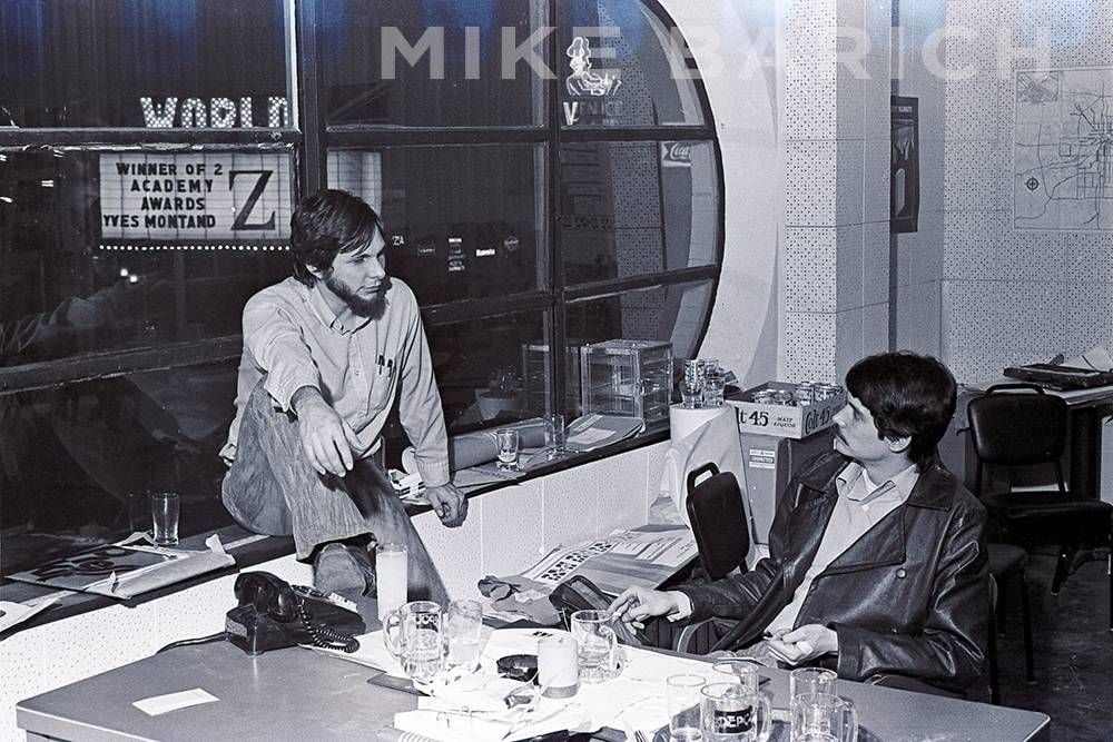 Employees in the upstairs office. 7th Street is visible below with the Venice Cafe and the World Theater.