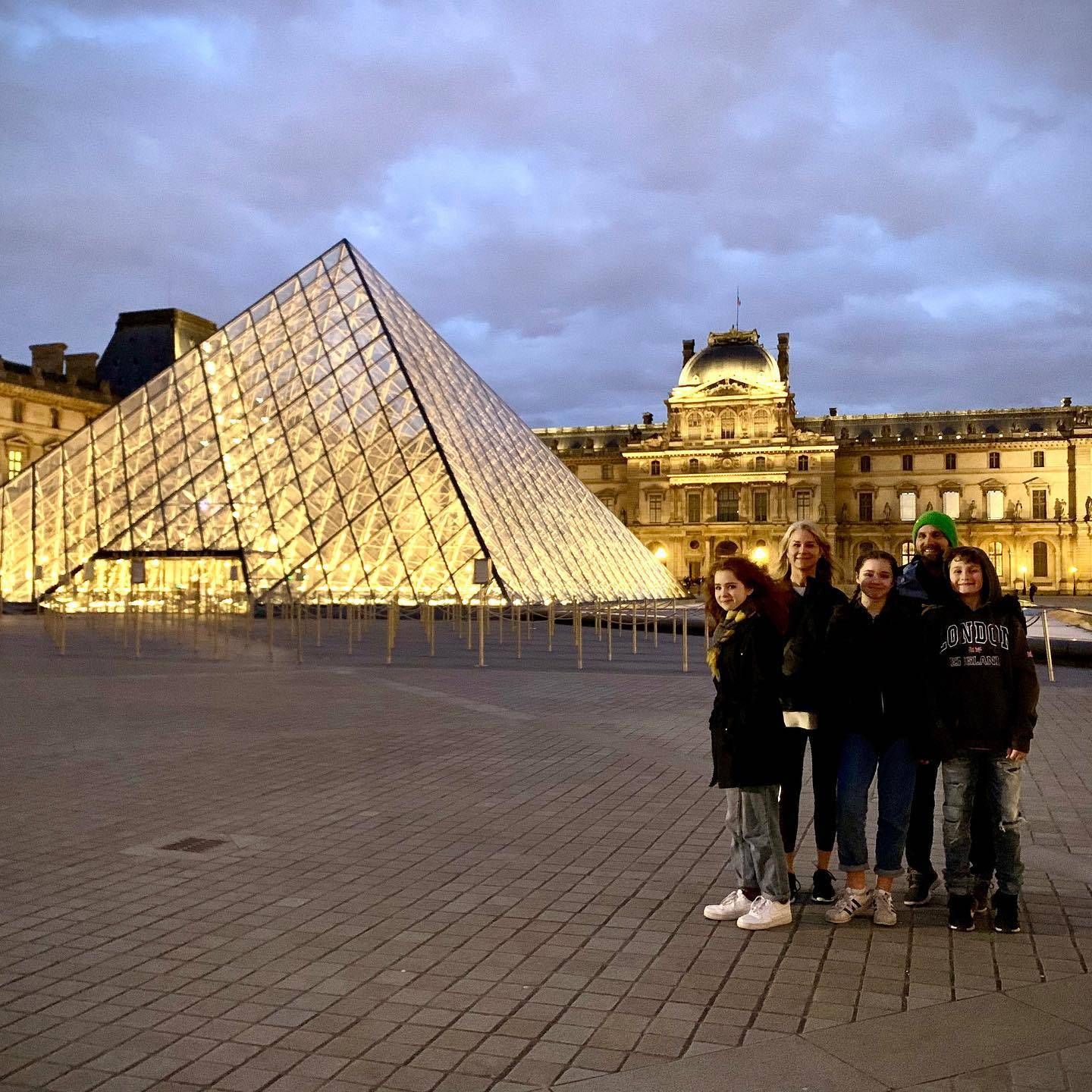 The family stands before the Louvre Pyramid shortly before the city went quiet.