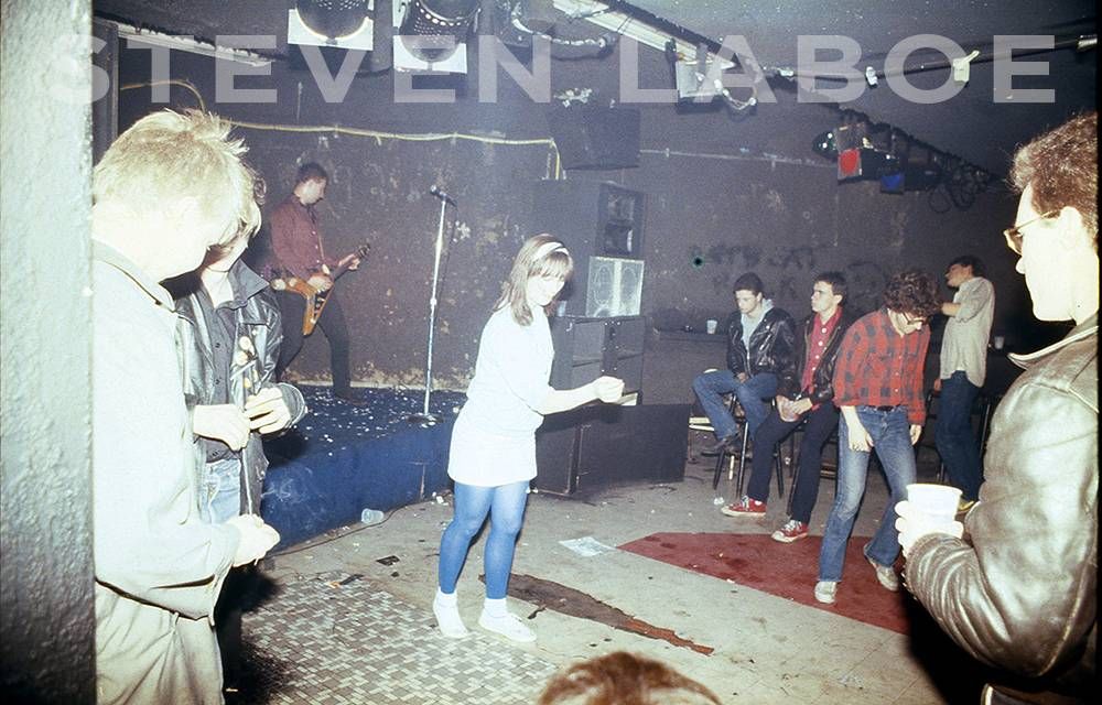 Hüsker Dü performing at 7th Street Entry, 1980. From the left front: the late Shawnian Pike, behind him is Tim Mitchell, Bob Mould, Eva Mosey Etoll, Tommy Hinsberger , Kelly Linehan, Mike Madden, Pat Woods is right front.