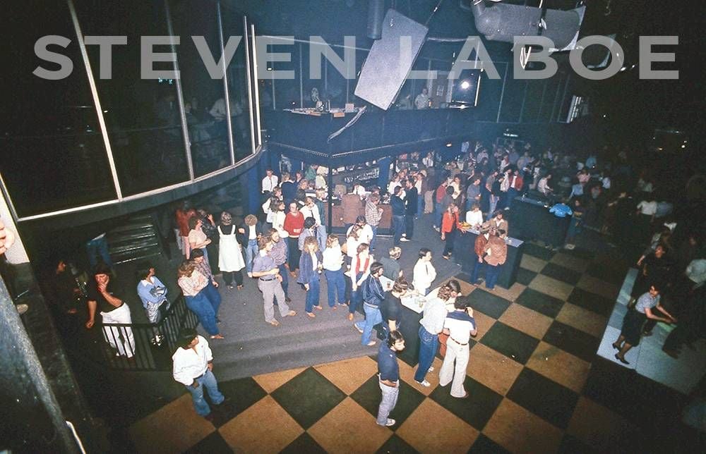 Main Room Bar at Sam's, 1981. "That DJ booth was a temporary platform," says Stephen McClellan, former Sam's manager. "I say temporary, because we did NOT have to call in the building inspectors when we installed it - and the city codes did NOT specify any time duration for 'temporary structures.' We bought it from a company that put 'temporary' shelving and storage structures in warehouse spaces.... And, I don't suppose if the inspectors didn't examine it after the ceiling caved in a few years back, it's still good as a temporary structure...."