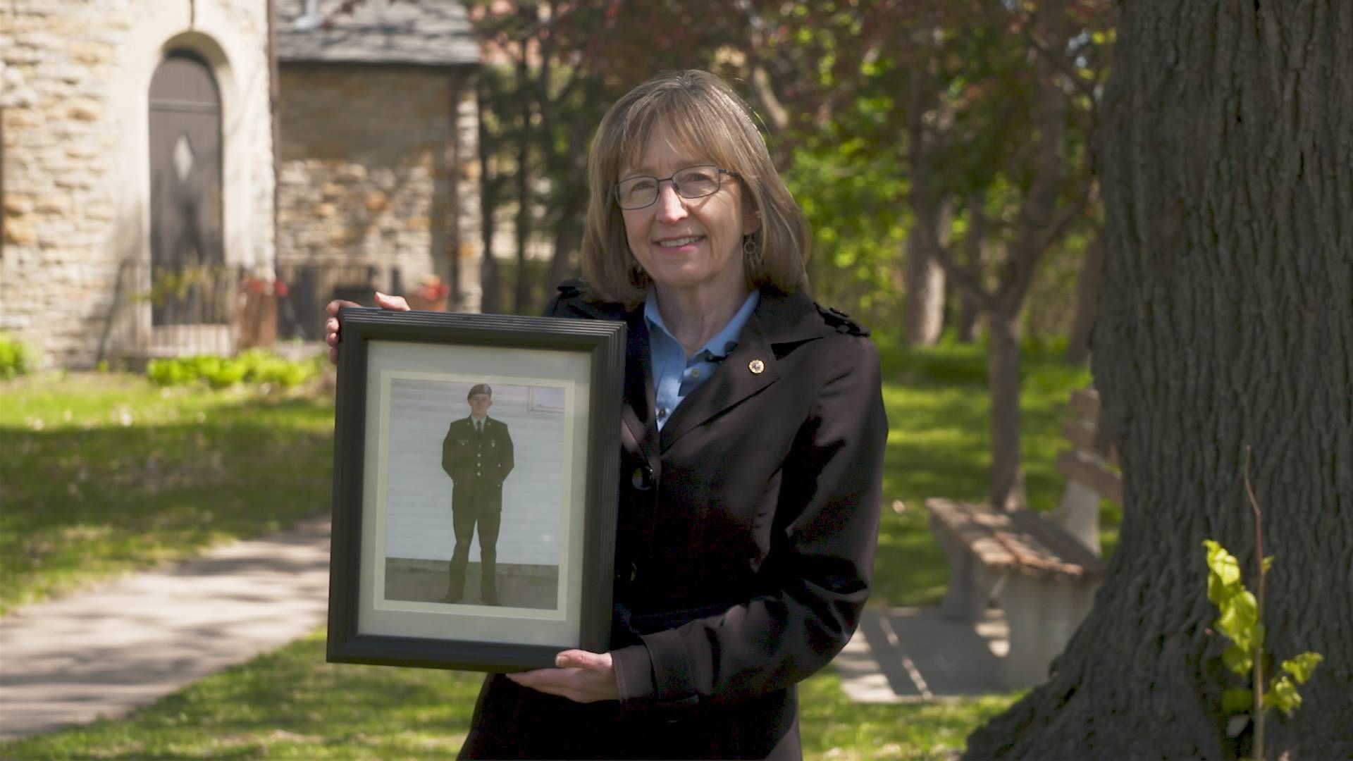 Sandy (Masterson) Lynch holding a photograph of her son Army Corporal Conor Masterson.