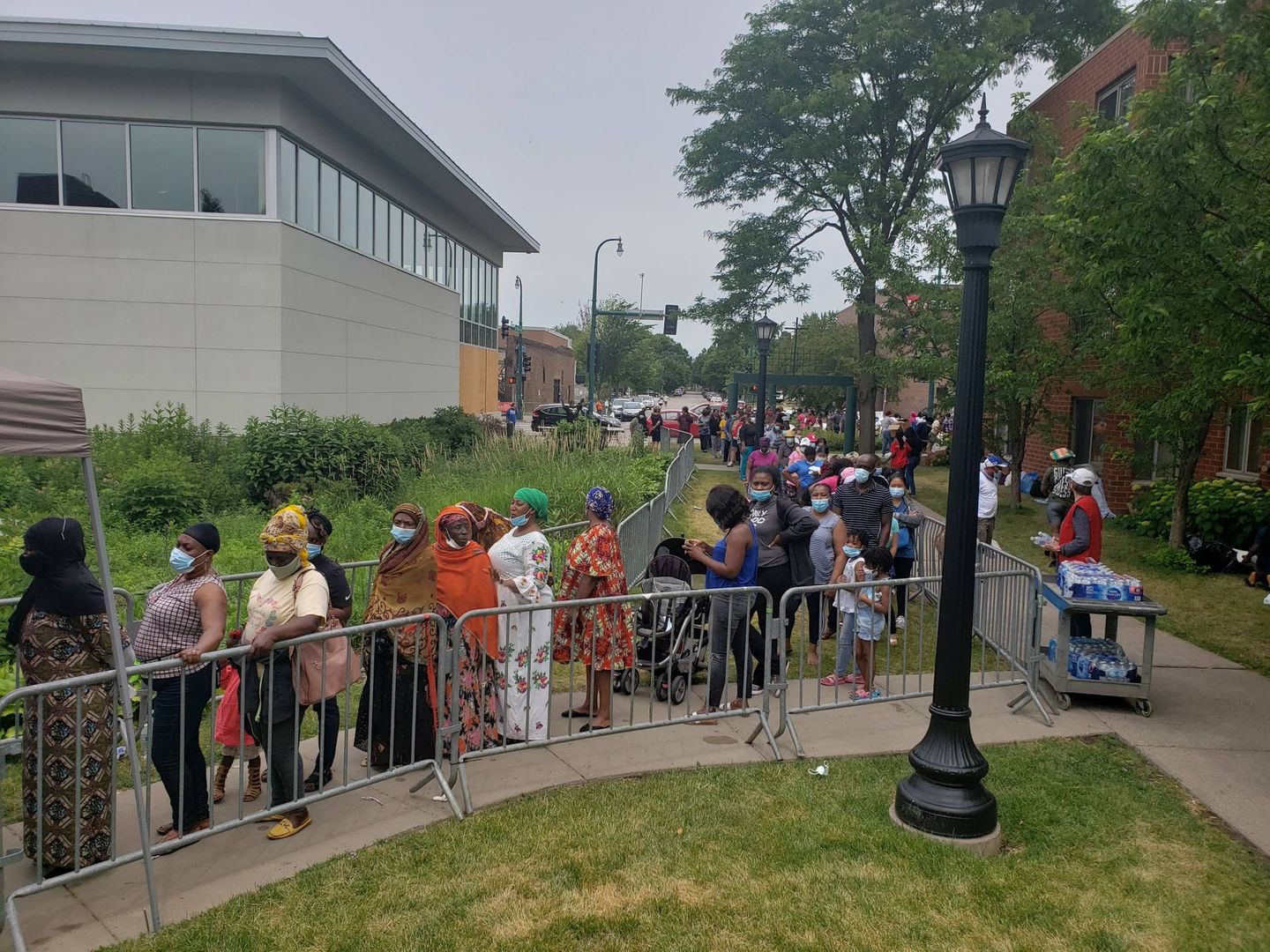 People wait in line for food at the Holy Trinity South Lutheran Church