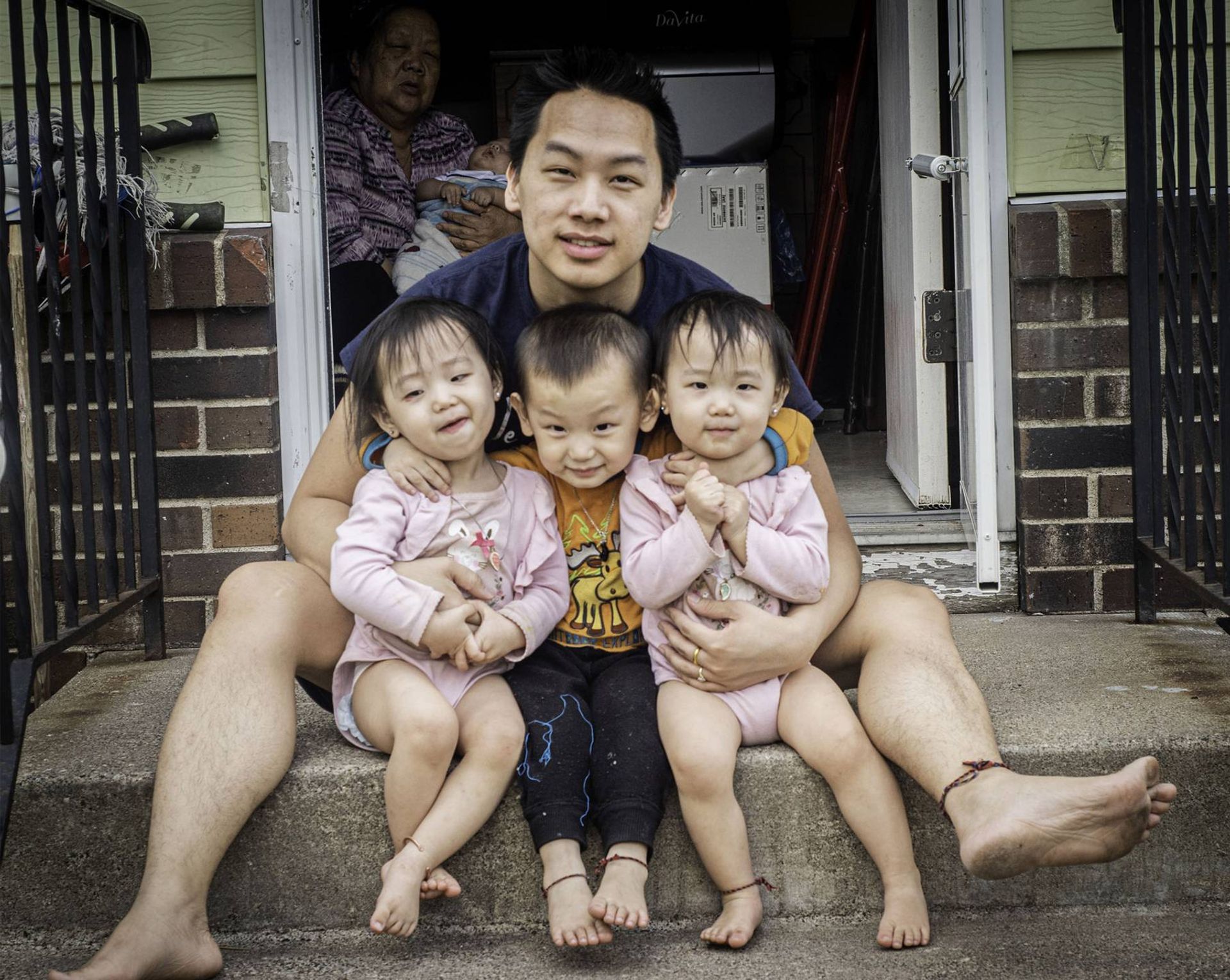 Photo of a father and three young children on steps
