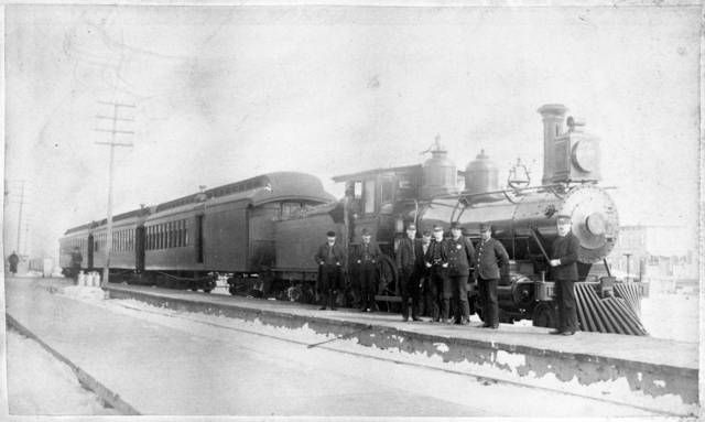 a group of people standing next to a train