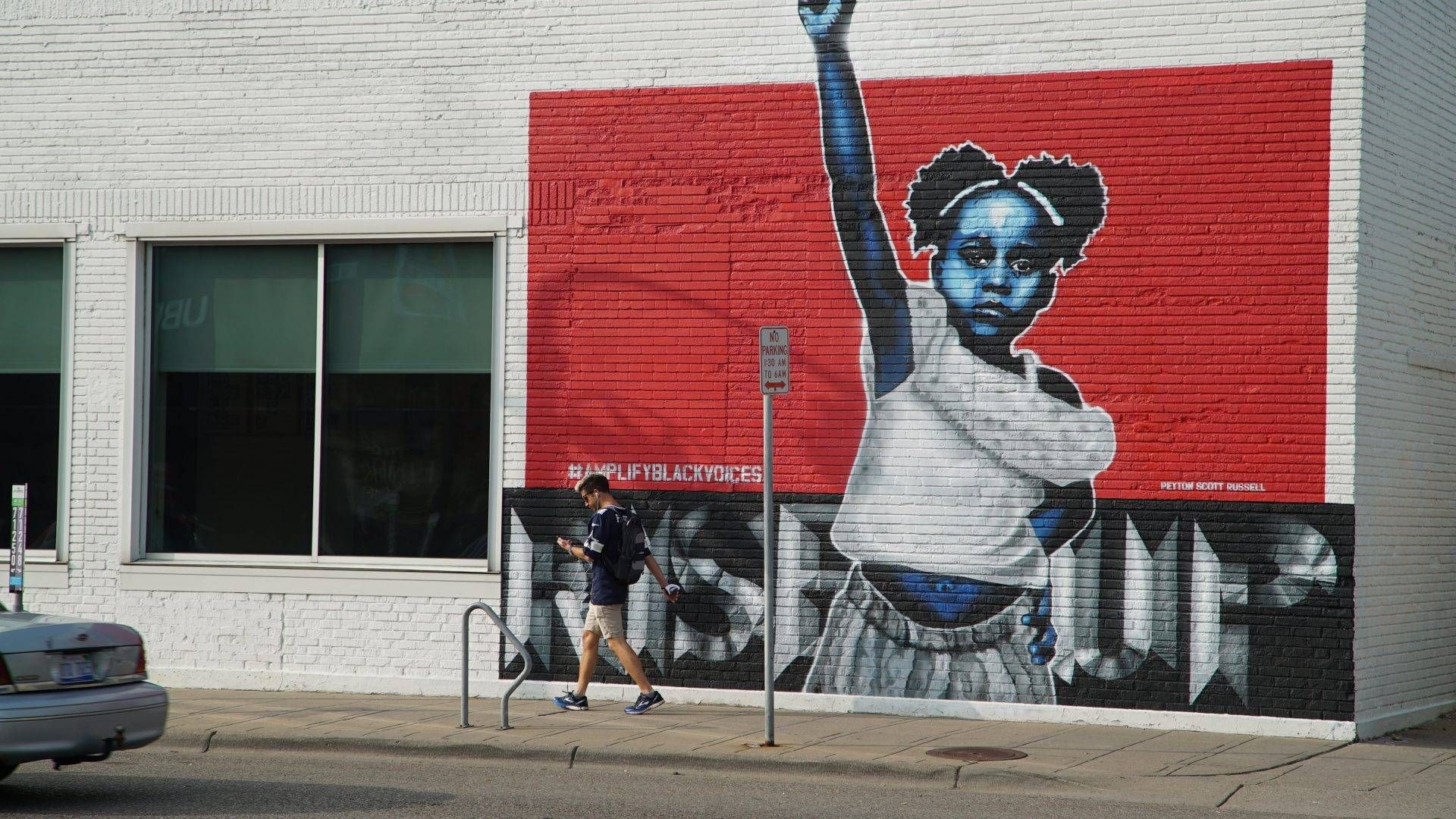 A man walks past a #AmplifyBlackVoices Mural along Lake Street on Sept. 20, 2020, where nearby protests months ago created a new food desert.