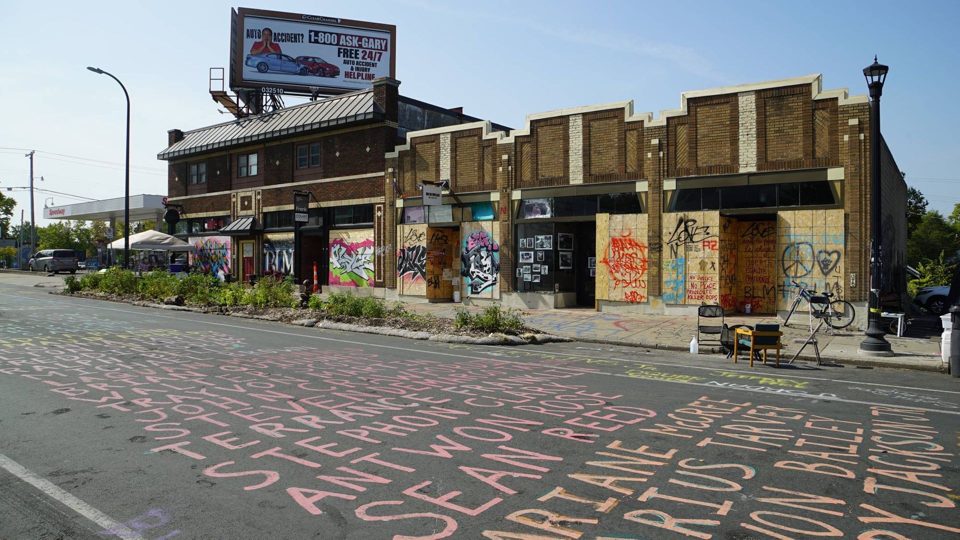 Shops boarded with graffitied plywood along the intersection of 38th and Chicago on Sept. 20, 2020, where Floyd died. Names of other Black Americans killed line the road.
