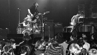 Man plays guitar while jumping in air
