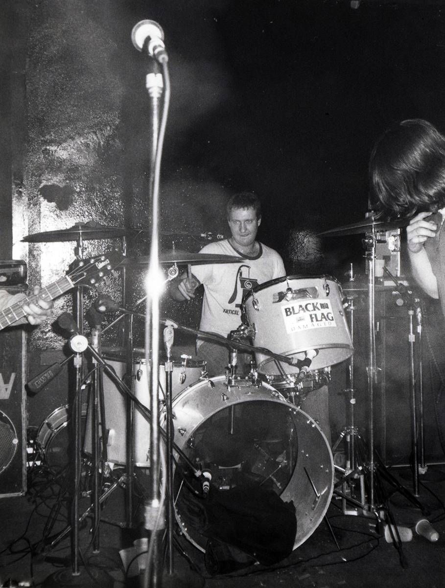 Bob Mould of Hüsker Dü plays the drum kit during a performance.