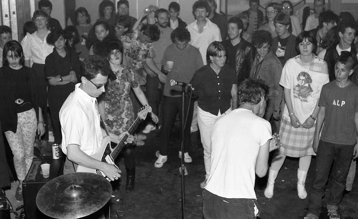 Rifle Sport playing a party in NE Minneapolis in 1983. The producer can be seen skulking in the right-hand corner wearing an ALP shirt.