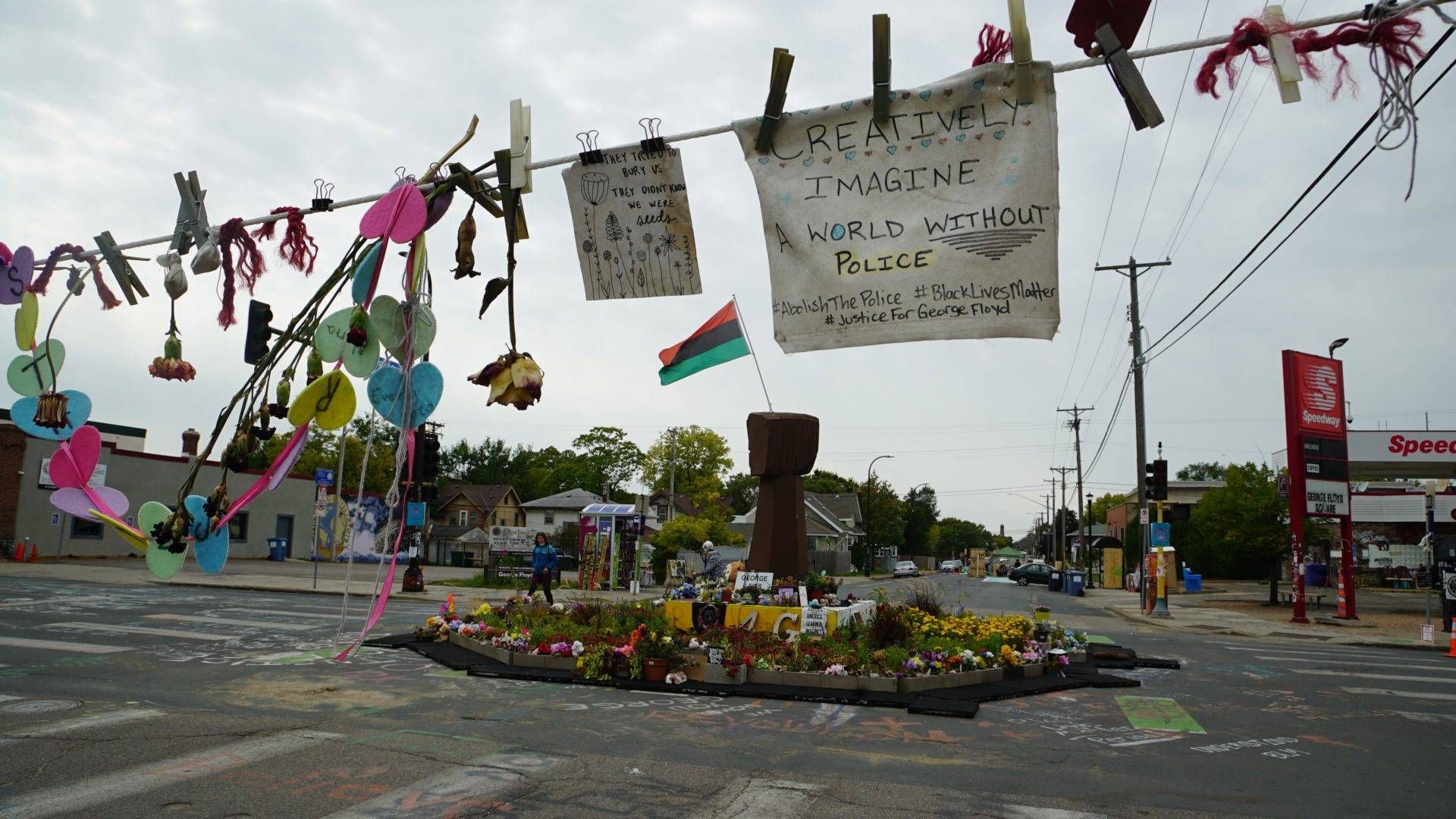 Trinkets, flowers and signs strung across the street at 38th and Chicago, where Floyd died earlier this year.