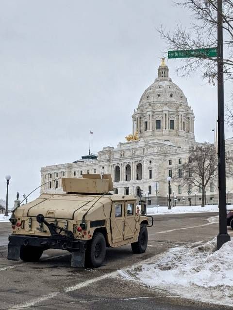 a military vehicle parked in front of a white building