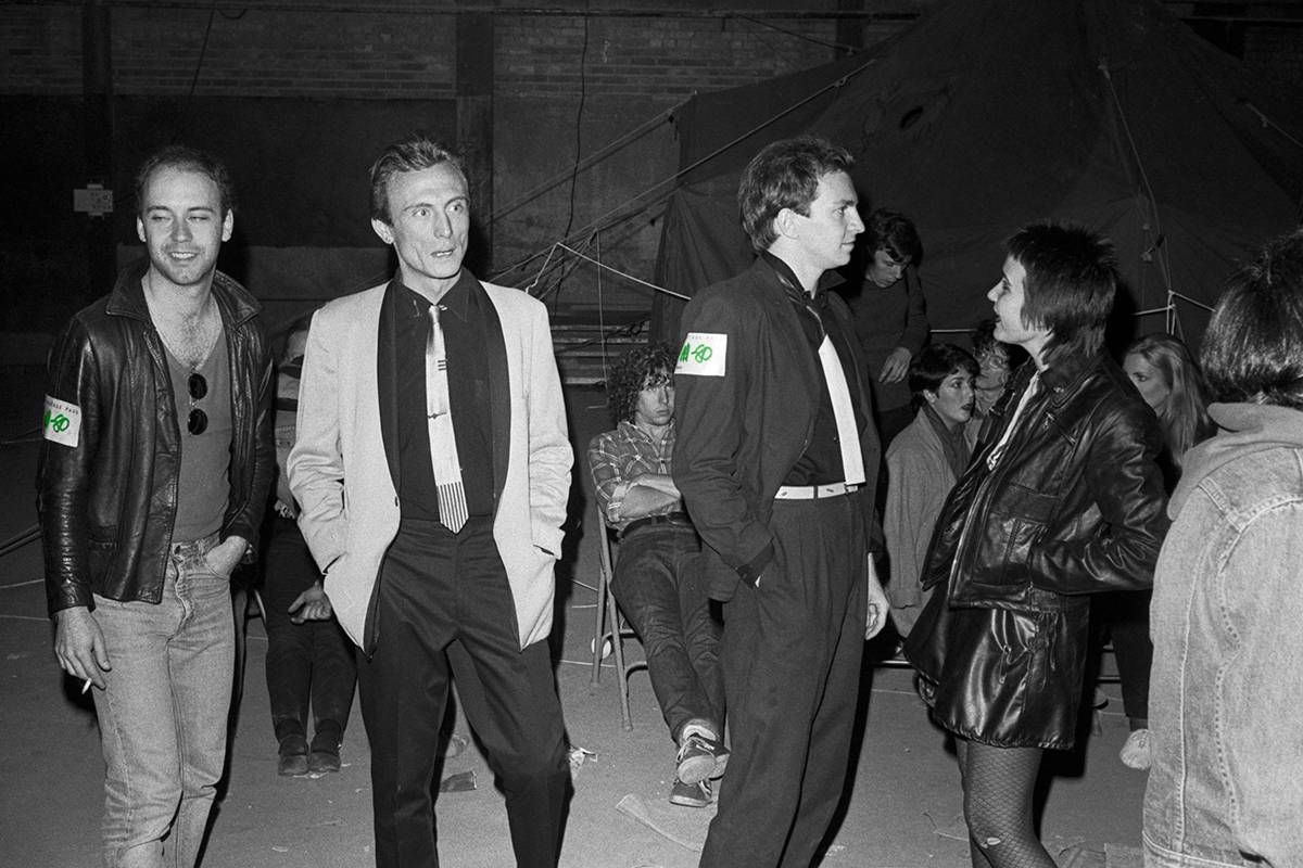 Backstage at M-80. Left to right: Mark Freeman from NNB, Patrick Geoffrois, Gerald Casale of Devo, unknown woman. Mark Mothersbaugh can be spotted in the background. Photo by Mike Barich.