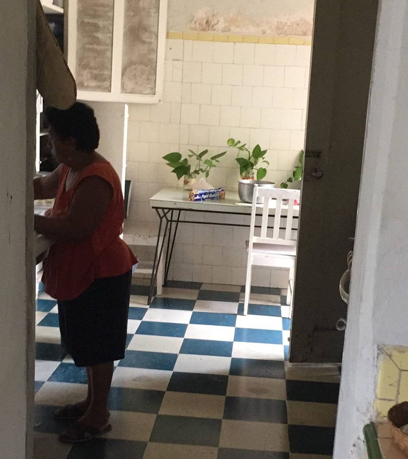 Dońa Polita prepares food in Guzman's grandmother's kitchen.