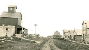 a dirt road with buildings on either side of it