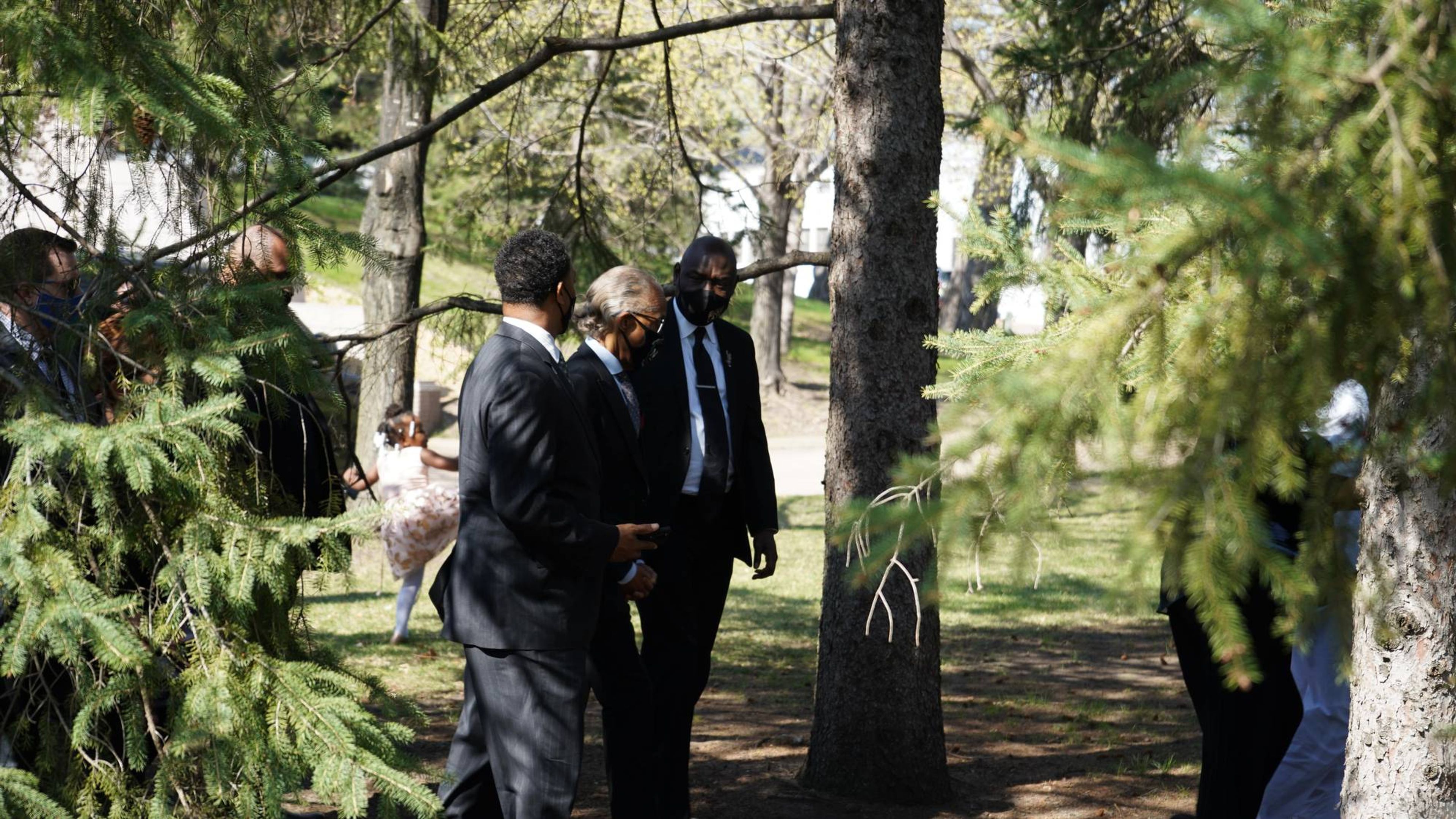 Reverend Sharpton and Attorney Ben Crump walk across the Lakewood Cemetery grounds.