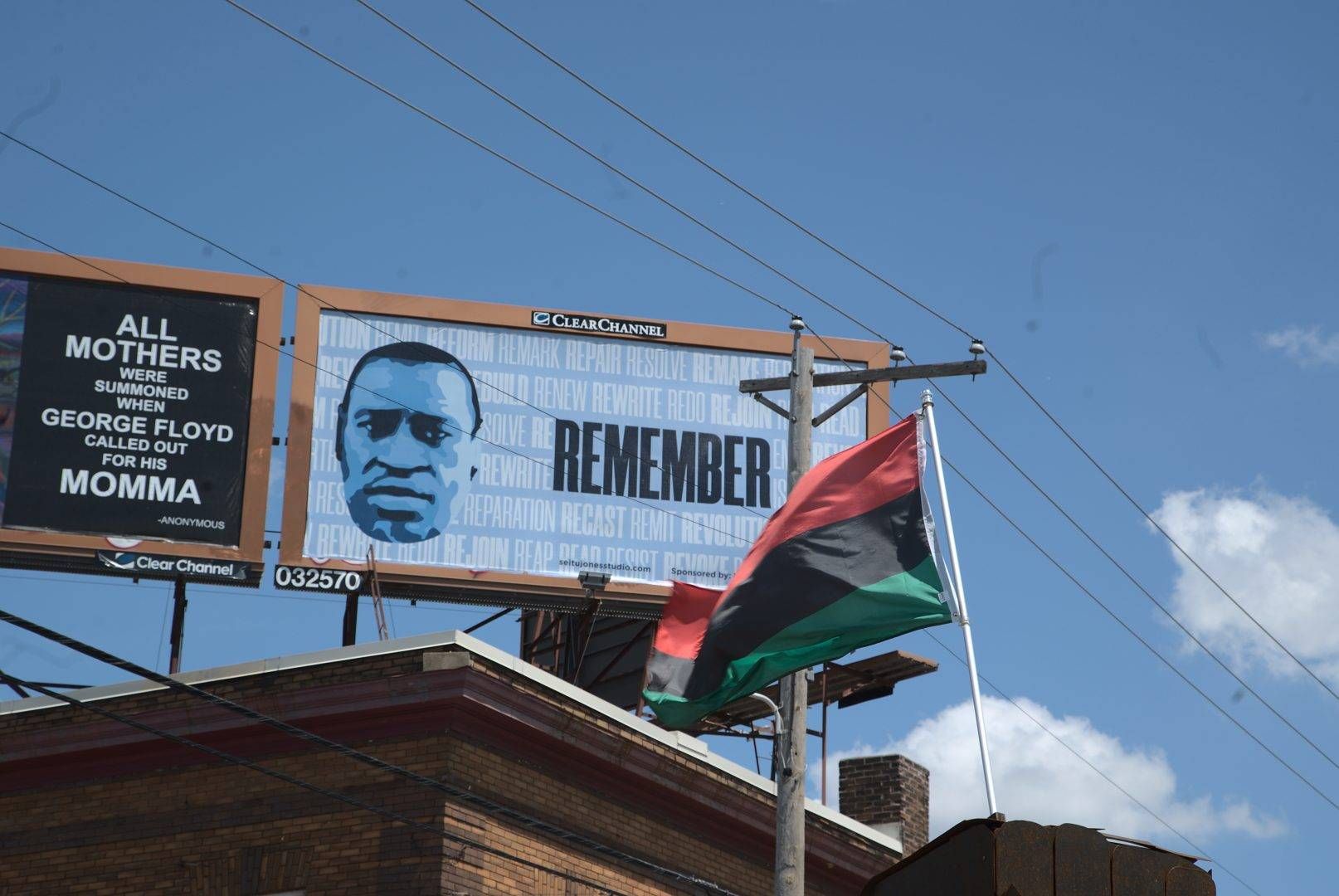 A flag waves in front of bill boards for George Floyd at the intersection of 38th and Chicago