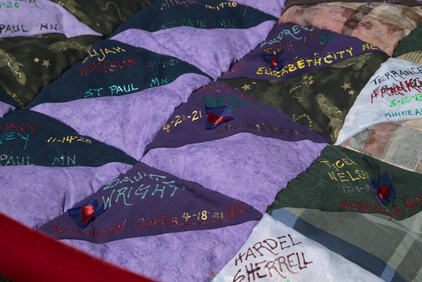 A quilt with Daunte Wright's name, and that of others, outside of the gravestone memorial near George Floyd Square