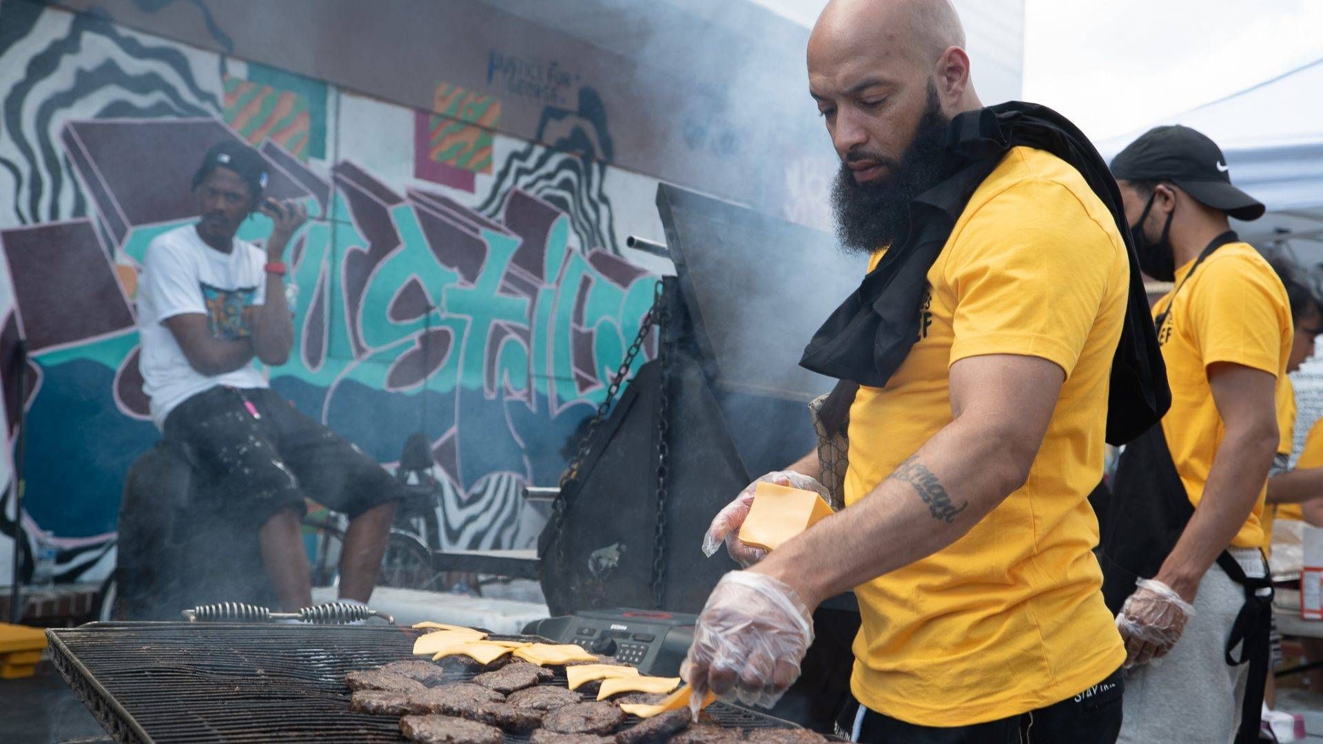 Members of the Twin Cities Relief initiative cook cheese burgers and hot dogs