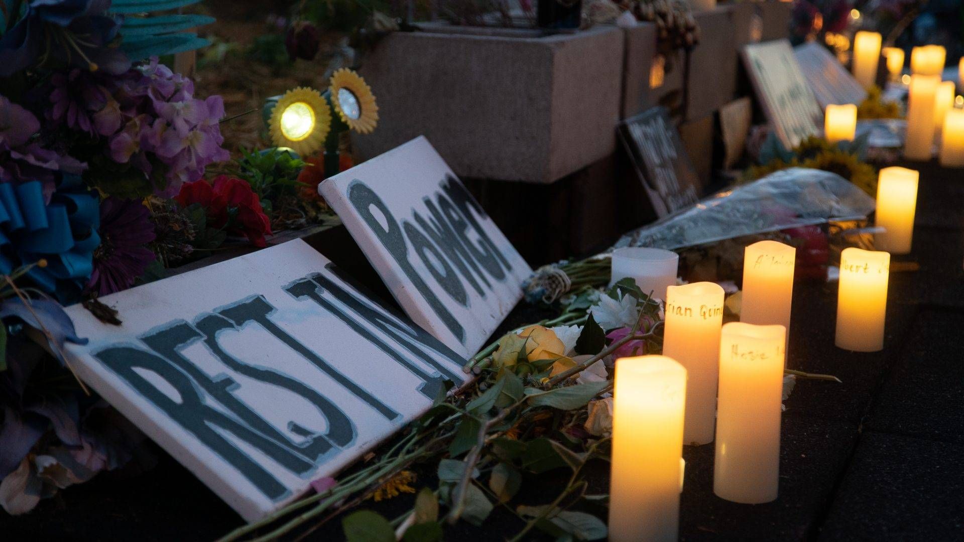 A sign reading "rest in power" is surrounded by flowers, candlelights and offerings. The nonprofit George Floyd Global Memorial has collected thousands of similar offerings.