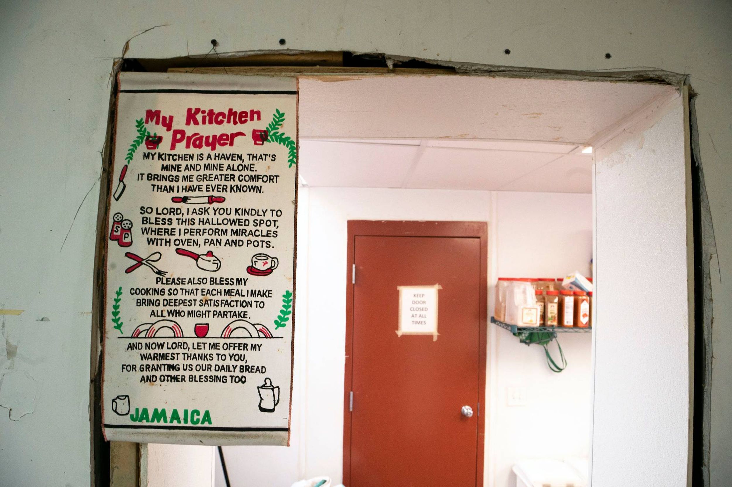 A poster of "My Kitchen Prayer" hangs near a service door.