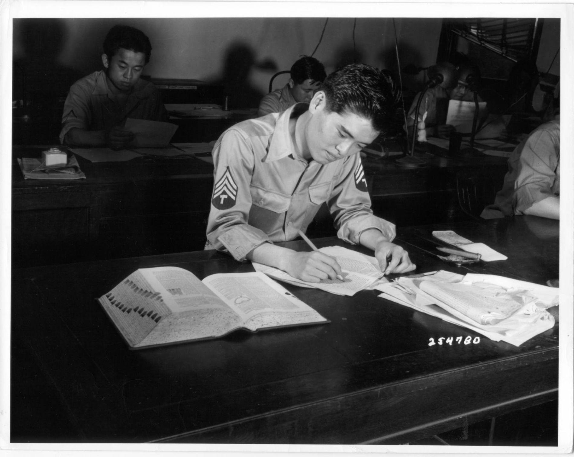 A Japanese-American soldier checks a document in Tokyo, Japan to determine its accuracy. | Credit: Densho