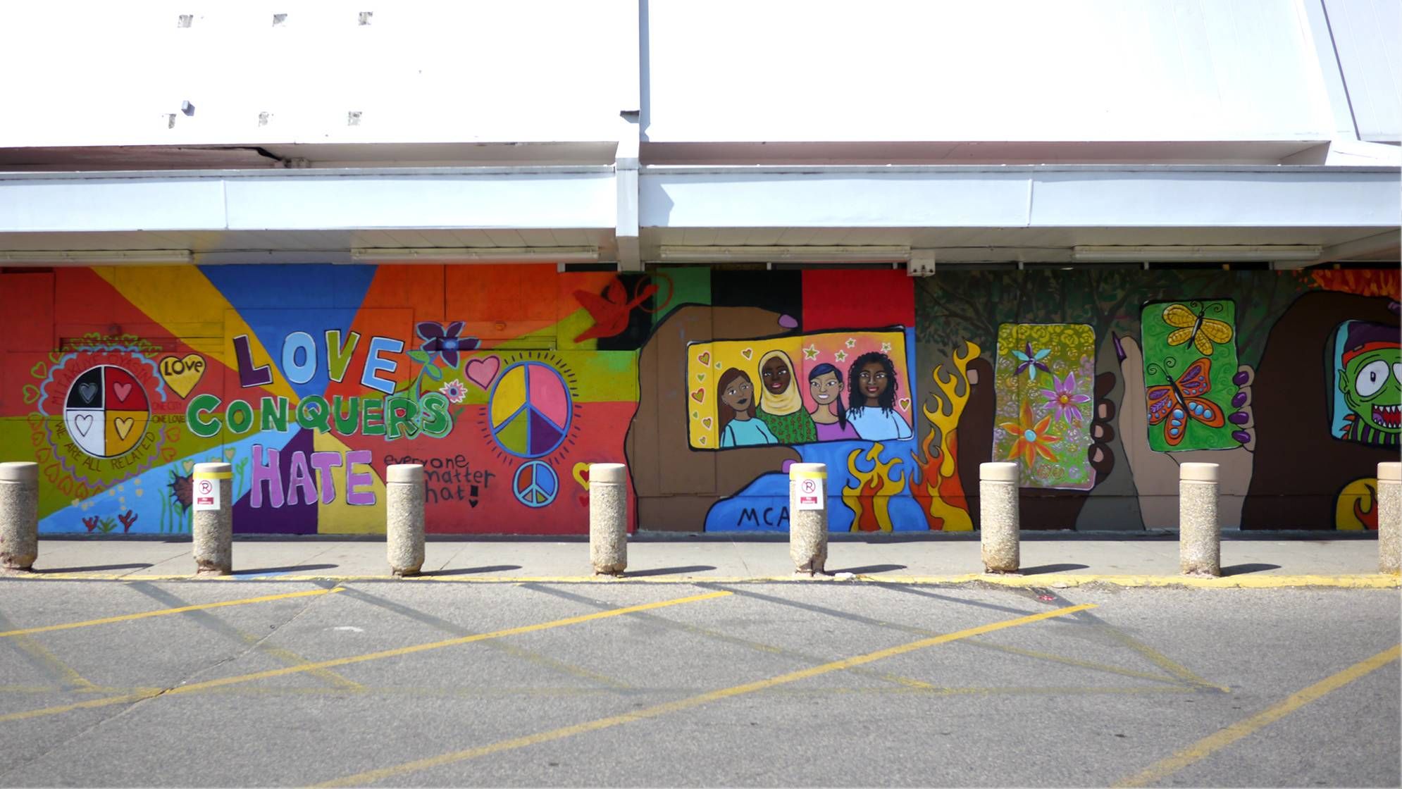 A colorful mural with the words "Love conquers hate."