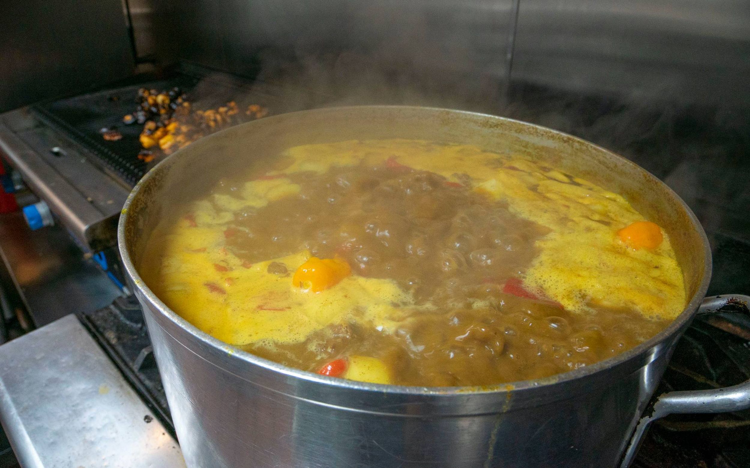 A large pot of curry simmers on the stove.