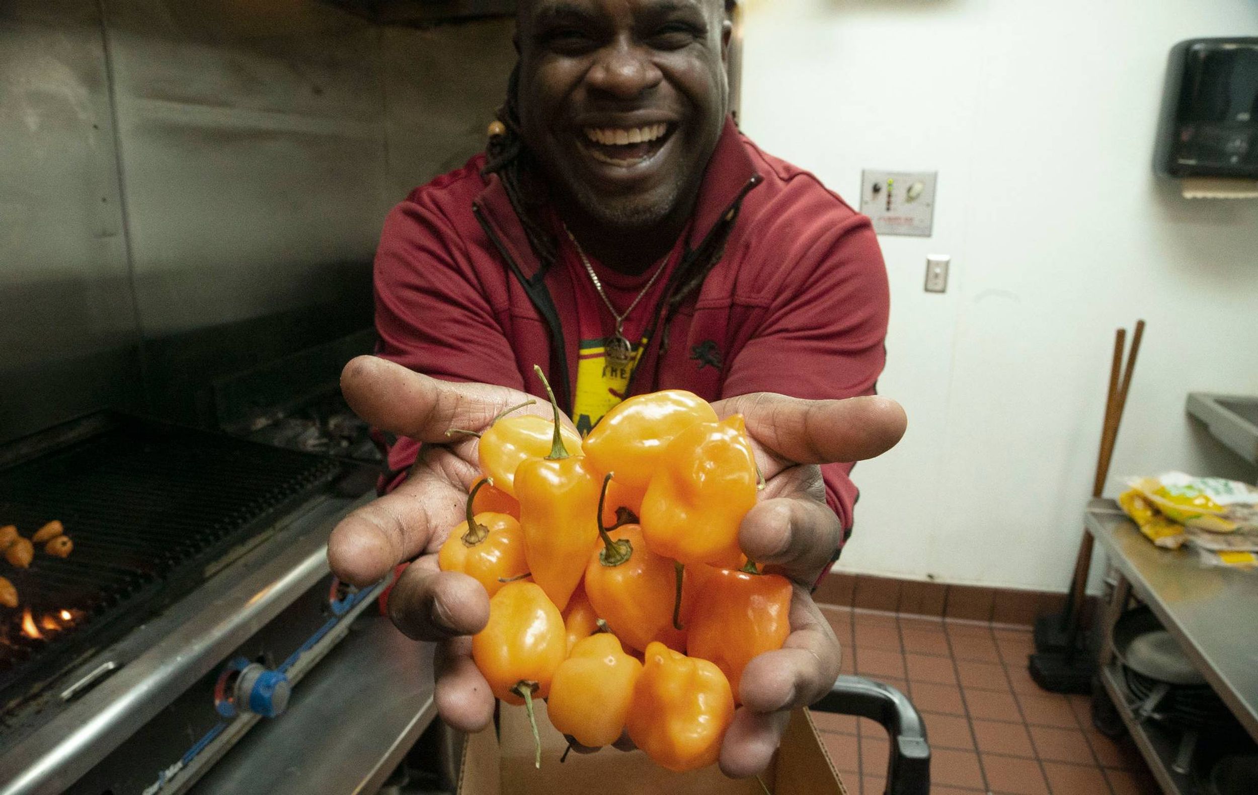 Tomme Beevas holds a handful of scotch bonnet peppers.