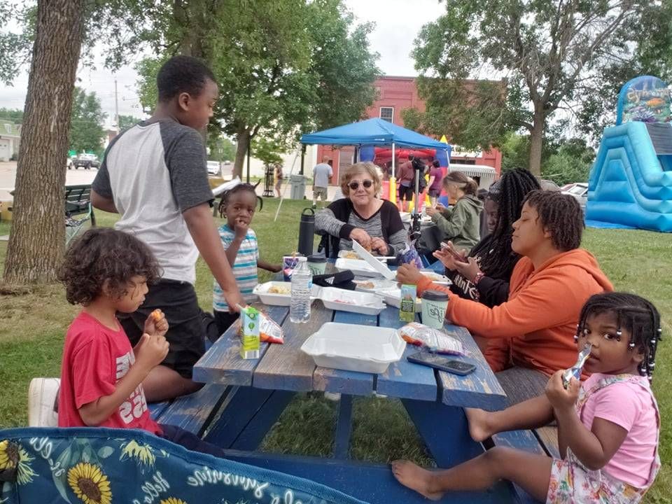 People eat and chat around a table at Chisholm's Juneteenth celebration