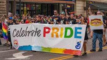 A photograph of the 2018 Twin Cities Pride parade with corporate logos on display.