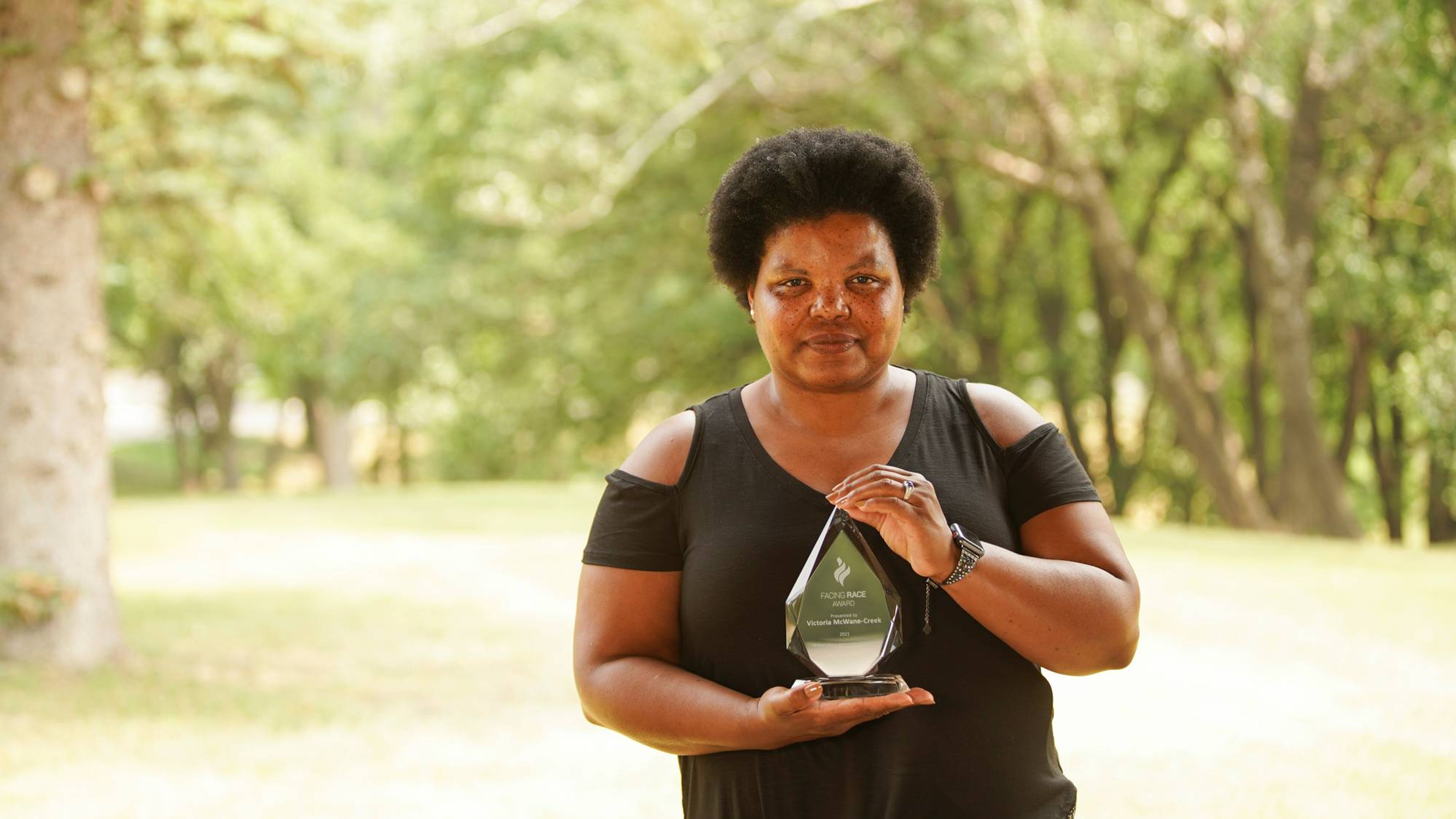 A woman poses with an award.