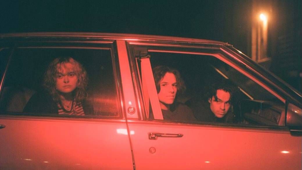 The Minneapolis band Ivers peeks out the windows of a car.