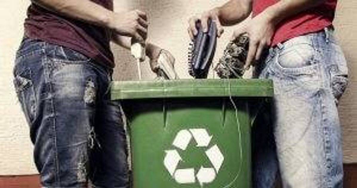 Two people putting broken electronics into a recycling bin pbs rewire