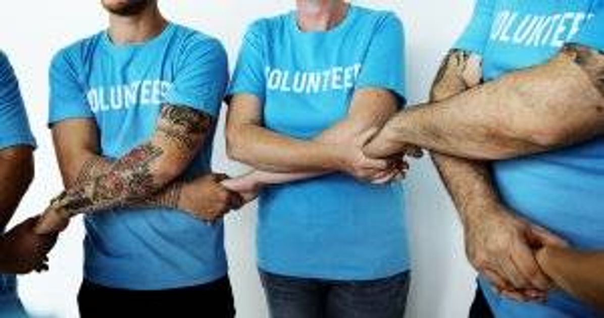 A group of volunteers holding hands. Nonprofit job pbs rewire