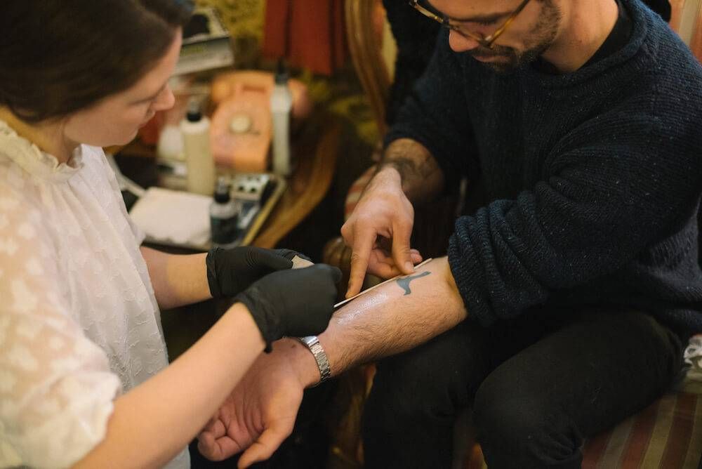 Tattoo artist Leah Marvin-Riley looks a client's arm to help decide on tattoo placement. Rewire PBS Living stick-and-poke