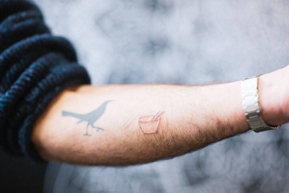 A photo of a close up of someone's arm, displaying a fresh tattoo of a bowl of noodles. Rewire PBS Living stick-and-poke