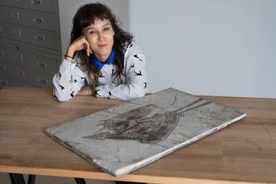 Photo of Jingmai O'Connor posing with an ancient bird fossil. pbs rewire