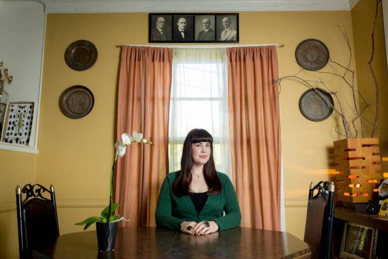 Photo of death-positive advocate and YouTuber Caitlin Doughty, a young woman with long black hair seated at a table. Rewire PBS Living Funeral
