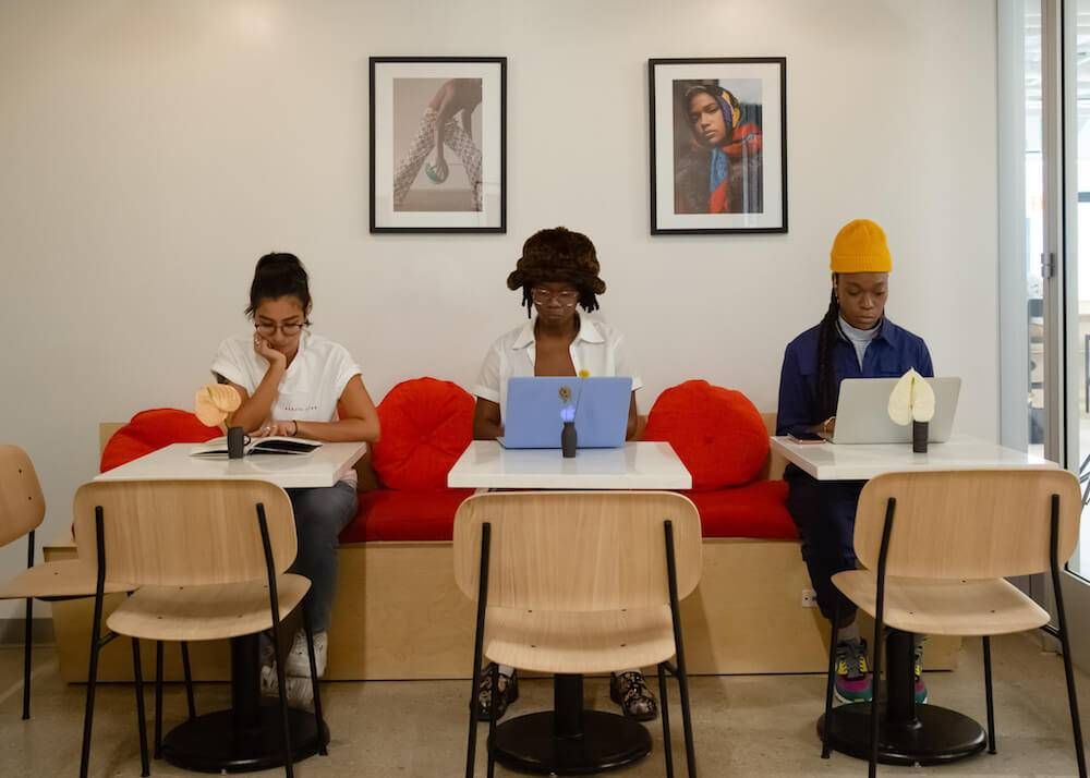 Photo of three people of color at work in a coworking space. Rewire PBS Work People of Color