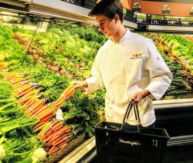 Man picking produce at the grocery store.