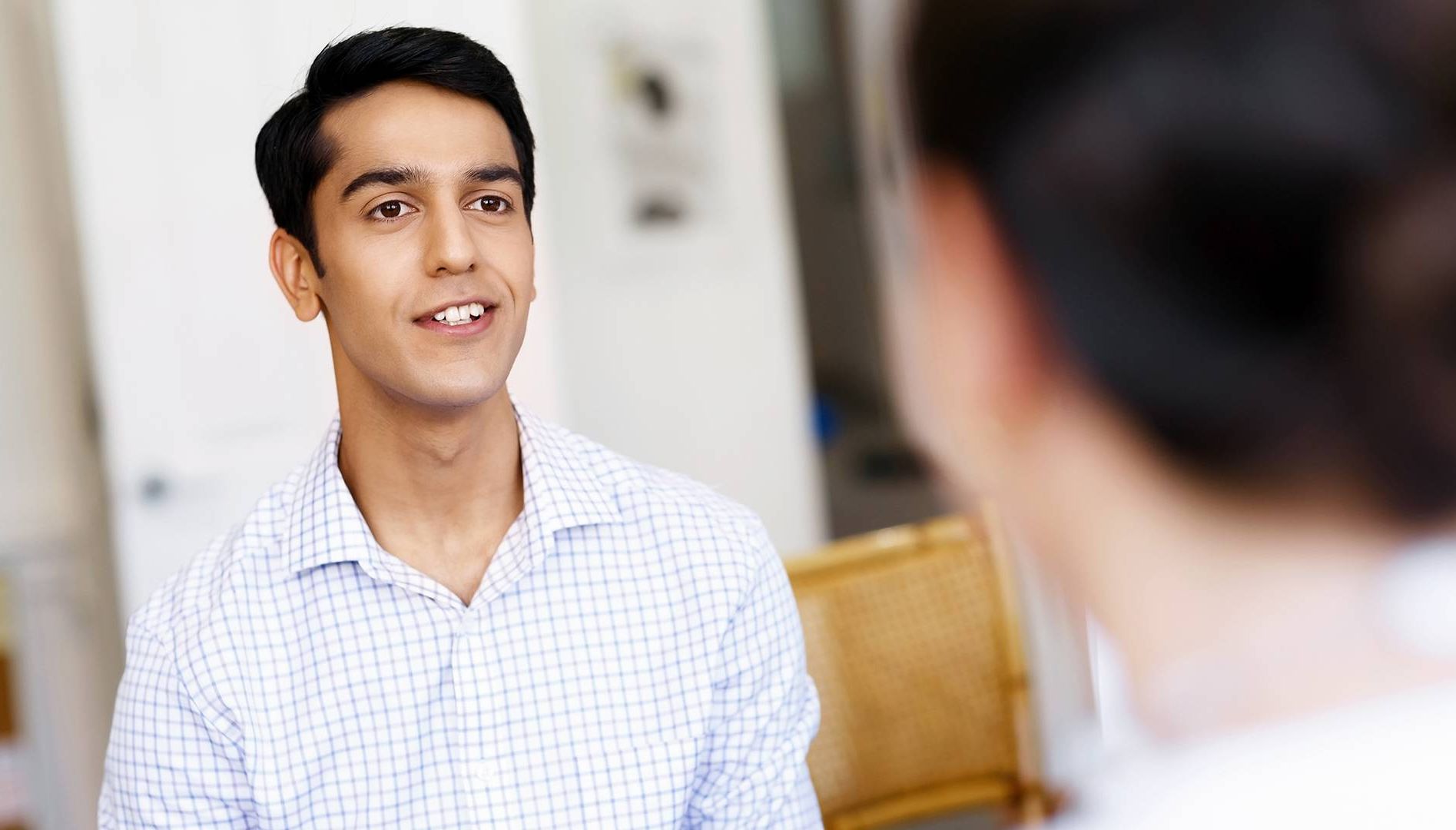A young man in a collared shirt smiles at an interviewer. Rewire PBS Work Skills