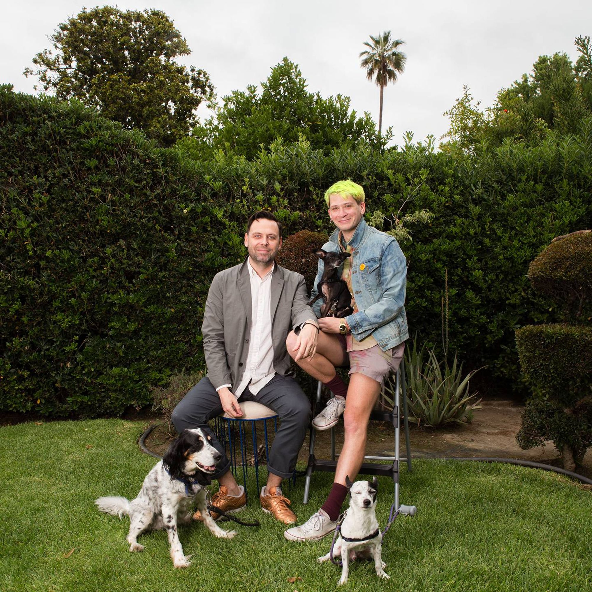 Posed photo of two men, one with lime green hair, and three dogs. Rewire PBS Our Future Queer History