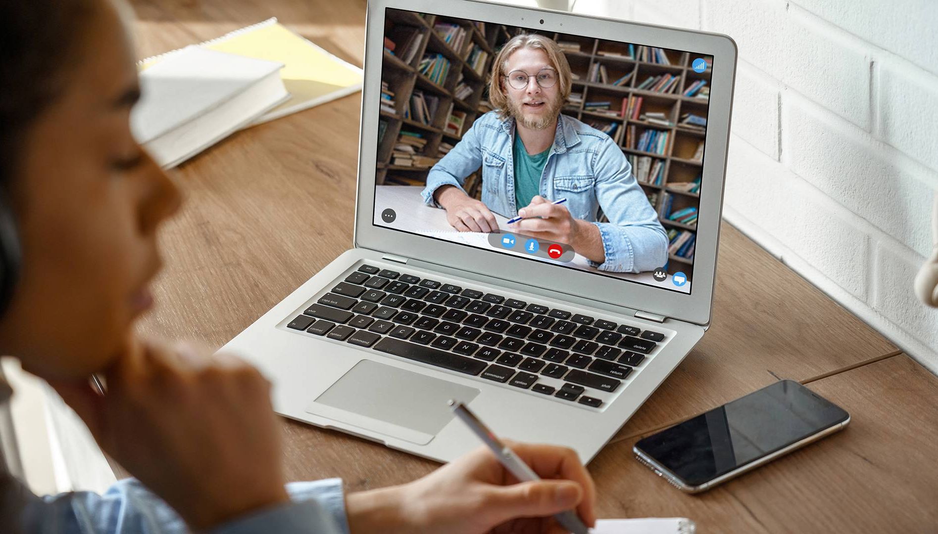 A young woman listens to a professor on video chat. Rewire PBS Our Future Online Schooling