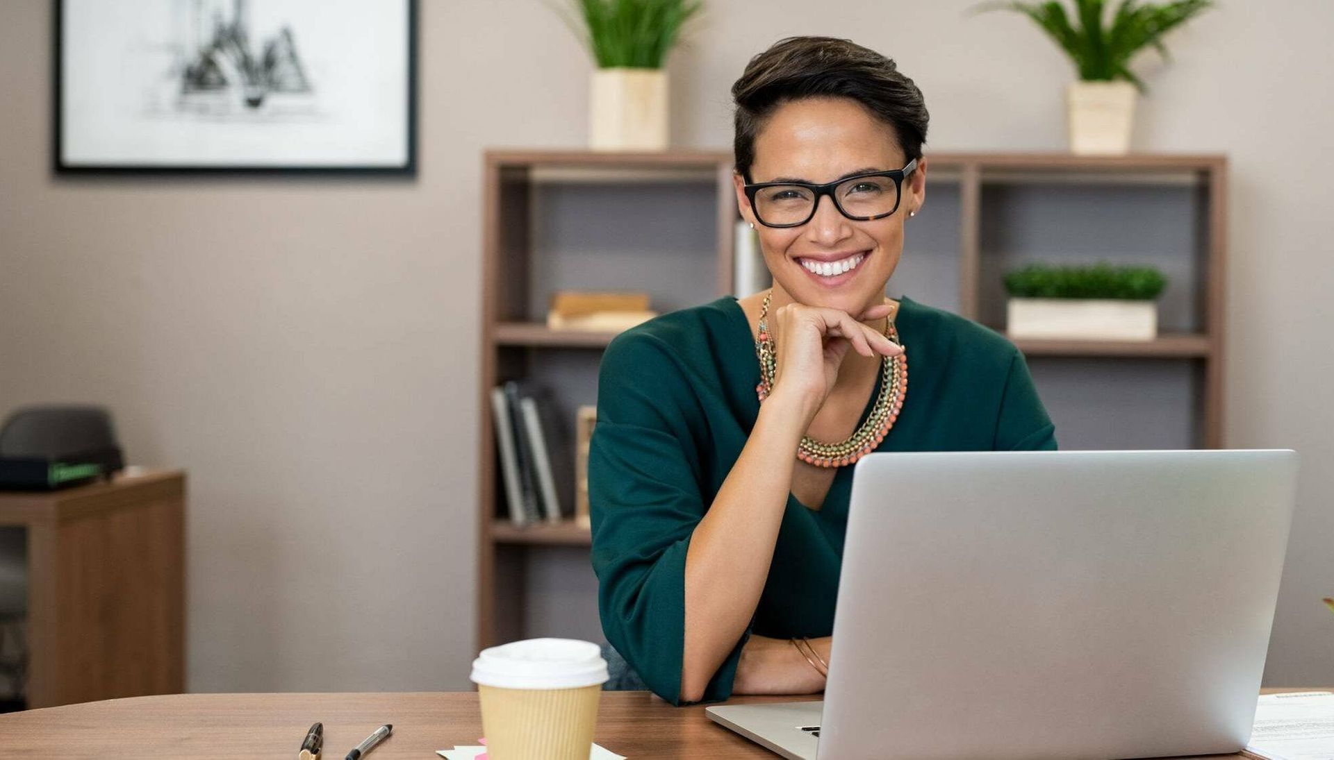 Woman sitting at laptop and smiling. Rewire PBS Work Introverts