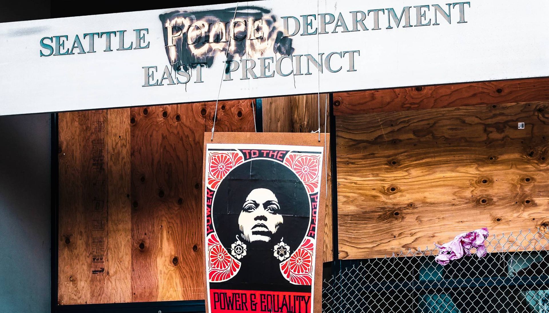 Seattle East Precinct Police Department sign defaced with Seattle People's Department and protest sign. Rewire PBS Our Future CHOP