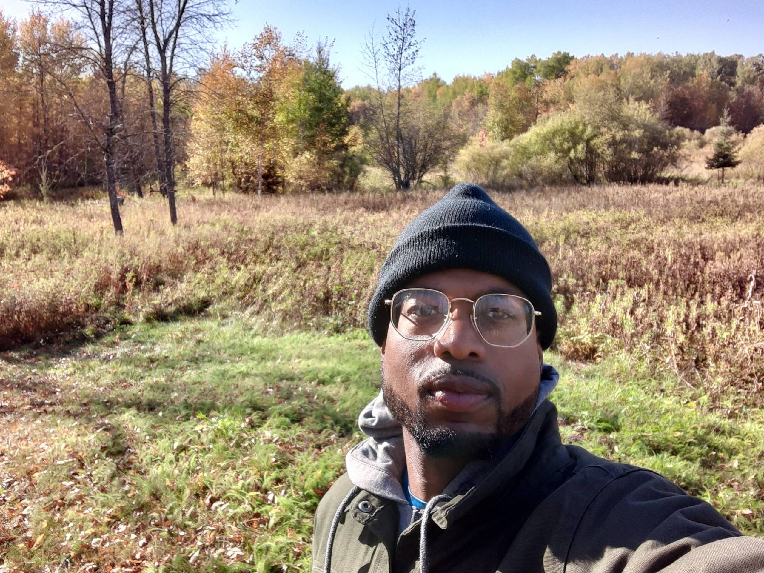 A selfie of Antonio Williams, a Black man, wearing glasses standing in a field. Rewire PBS Our Future Can't Vote