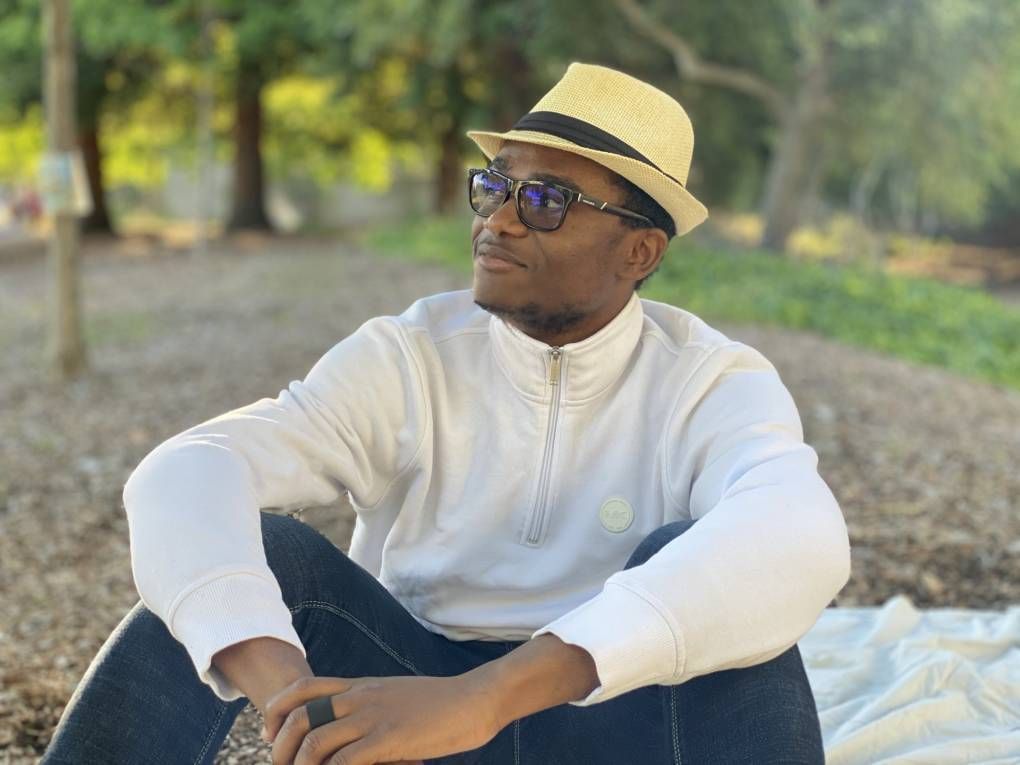 Student Abdoul Aziz Sandotin Coulibaly sits on the ground, looking off camera. Rewire PBS Our Future Berkeley
