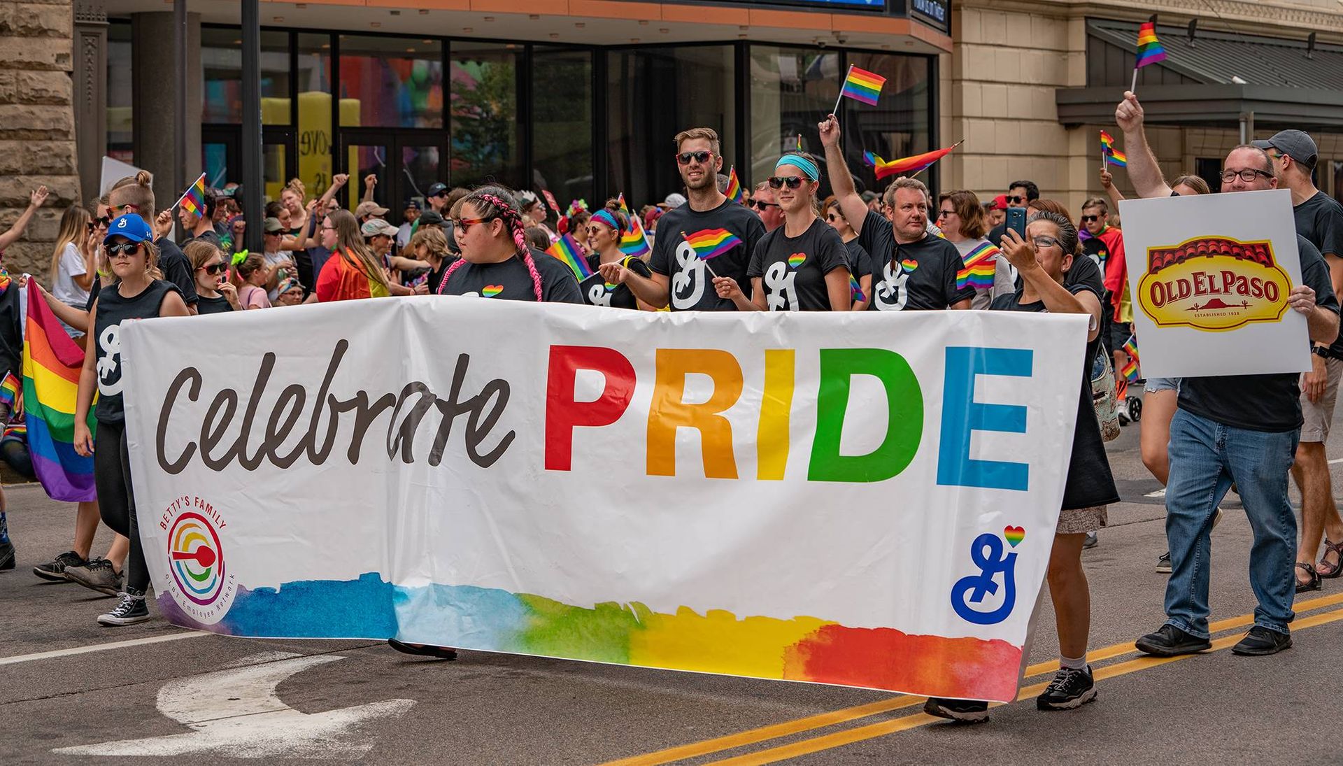 Photo of a Pride parade with corporate logos on display.