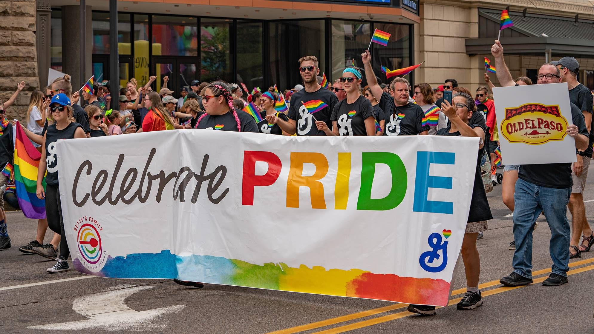 Photo of a Pride parade with corporate logos on display. pride, taking back pride