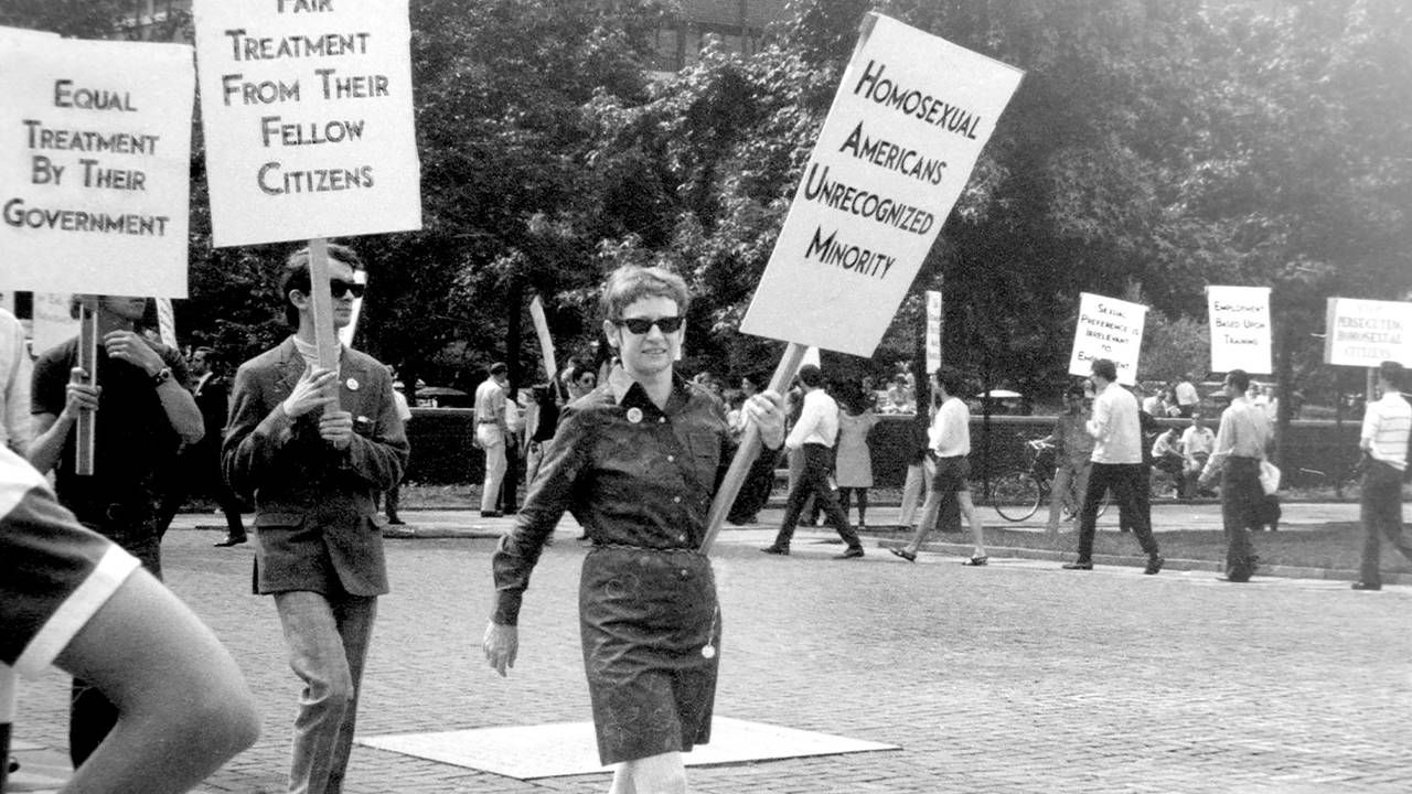 An old photograph of LGBTQ activists marching with signs. 'CURED' documentary, Rewire, PBS